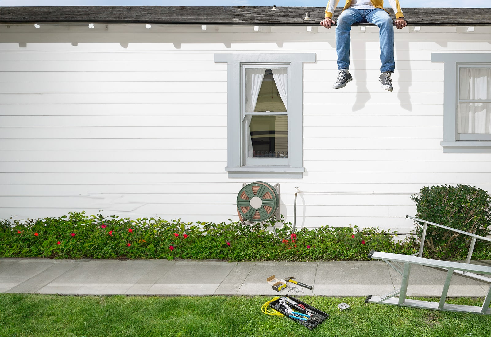 diy roofing feature - not recommended - home owner hanging from roof